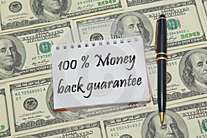 Notebook page with text 100% MONEY BACK GUARANTEE on dollar background