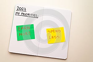 Notebook page, with text `2023 priorities: spend less, earn more` photo