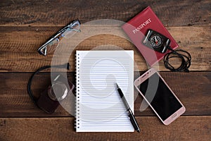 Notebook, passport, camera, compass and smarphone on a wooden table photo