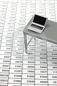 Notebook PC and business documents with numbers and charts.