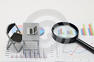 Notebook PC and business documents with numbers and charts.