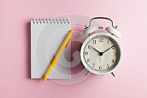 Notebook, pen, alarm clock. Blank card for to-do list, timetables, text, design. Concept of time, deadline. Copy space