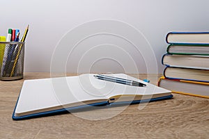 Notebook with pen, books and pens