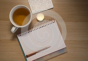 Notebook, pen and cup on wooden table