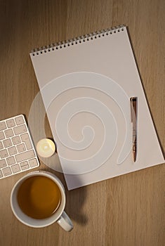 Notebook, pen and cup on wooden table