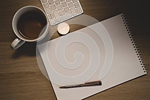 Notebook, pen and cup on wooden table