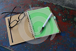 Notebook, pen and eyeglasses