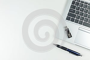 Notebook, pen, flash drive lie on a white background, top view