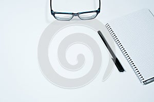Notebook, pen, glasses isolated on white background. Office desk with copy space
