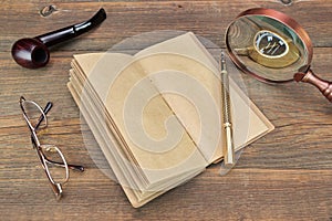 Notebook, Pen, Glasses, Magnifier and Smoking Pipe On Wood Background