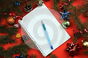 Notebook with pen lies on the background of Christmas decoration