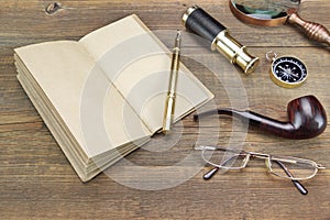 Notebook, Pen, Magnifier, Cpmpass, Pipe, Spyglass On Wood Background