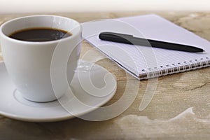 Notebook with pen for notes and black coffee