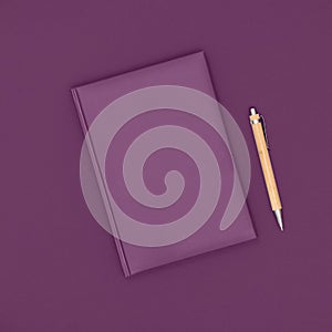 Notebook and pen on purple background. Business concept. Top view, flat lay, copy space