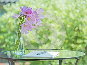 Notebook, pen on table in Park garden, bouquet of flowers, empty