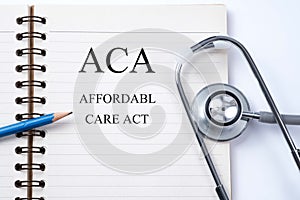 Notebook and pencil with ACA Affordable Care Act on the table