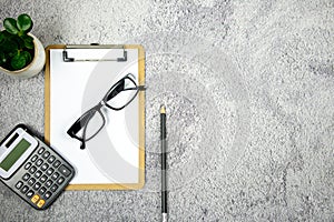 A notebook with pencil, calculator and eye glasses on the desk. - Business concept.