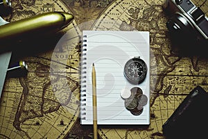 Notebook, pencil, camera, compass, coin, wallet, airplane on blur vintage world map, journey concept, copy space, retro tone