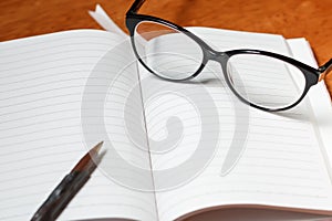 notebook, pencil and glasses
