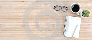 Notebook with pencil , glasses, small tree and coffee on old wooden table.Top view