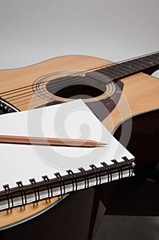 Notebook and pencil on guitar