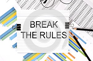 Notebook with pencils, glasses on the graph background, with text BREAK THE RULES