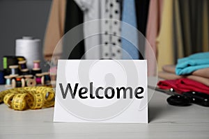 Notebook with phrase Welcome Back and sewing accessories on table photo