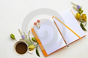 Notebook planner for business work with hot coffee, yellow flowers ylang ylang
