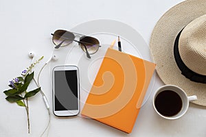 Notebook planner ,mobile phone and hot coffee for business work with sunglasses ,hat of lifestyle