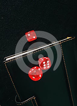 Notebook and poker dice on the black background