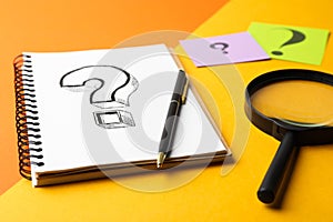 Notebook with question mark, pen and magnifier glass on color background