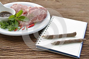 Notebook for recipes and raw pork with spices