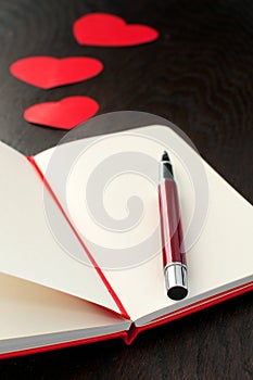 Notebook with red pen and hearts