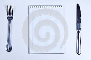 Notebook with Silver Cutlery. Lined blank notebook with spiral and silver cutlery, fork and knife