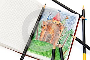 Notebook with a sketch of a fairy castle & pencils