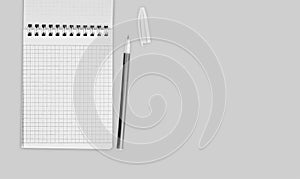 Notebook with spiral and ballpoint pen on gray background, black and white, top view, copy space, place for text