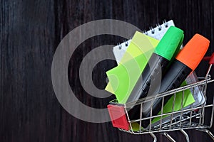 Notebook, stickers and highlighters in a shopping cart