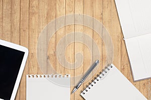 Notebook and tablet on wood table