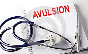 Notebook with text AVULSION with pen and stethoscope