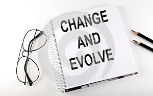 Notebook with text Change and Evolve on white background