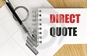 Notebook with text direct quote on desk with pen and black charts on white paper