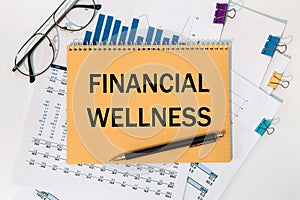 Notebook with text Financial Wellness near office supplies