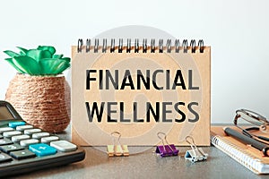 Notebook with text Financial Wellness near office supplies