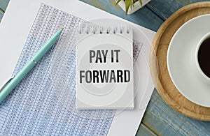 Notebook with text PAY IT FORWARD .