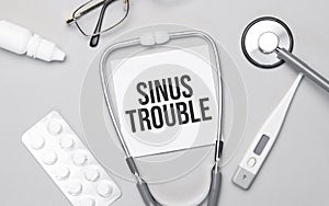 In the notebook is the text sinus trouble, stethoscope, pills, and glasses