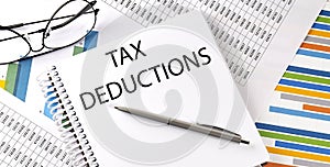 Notebook with text TAX DEDUCTIONS . Diagram and white background,Business concept photo