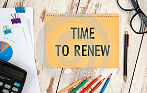 Notebook with text - Time to renew near office supplies