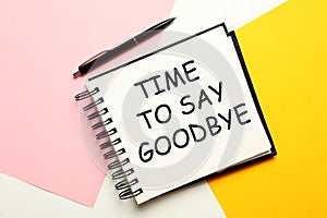 Notebook with text Time to say goodbye on color background, flat lay