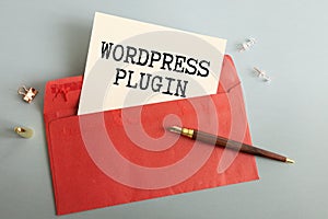 A notebook with the text WORDPRESS PLUGIN, a pen and glasses
