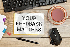 Notebook with text YOUR FEEDBACK MATTERS near office supplies